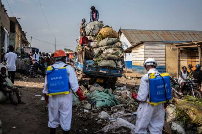 Sanitation workers from Bunia city government spray disinfectant in the central market area near a rubbish truck in Ituri province, as they continue efforts to combat the Ebola outbreak in Bunia, Congo, Saturday, May 23, 2026.
