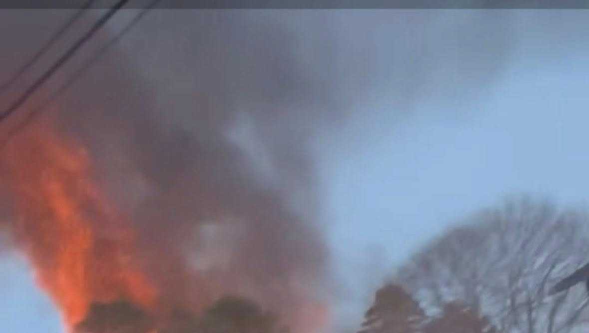 Heavy flames engulf multiple sheds, trees