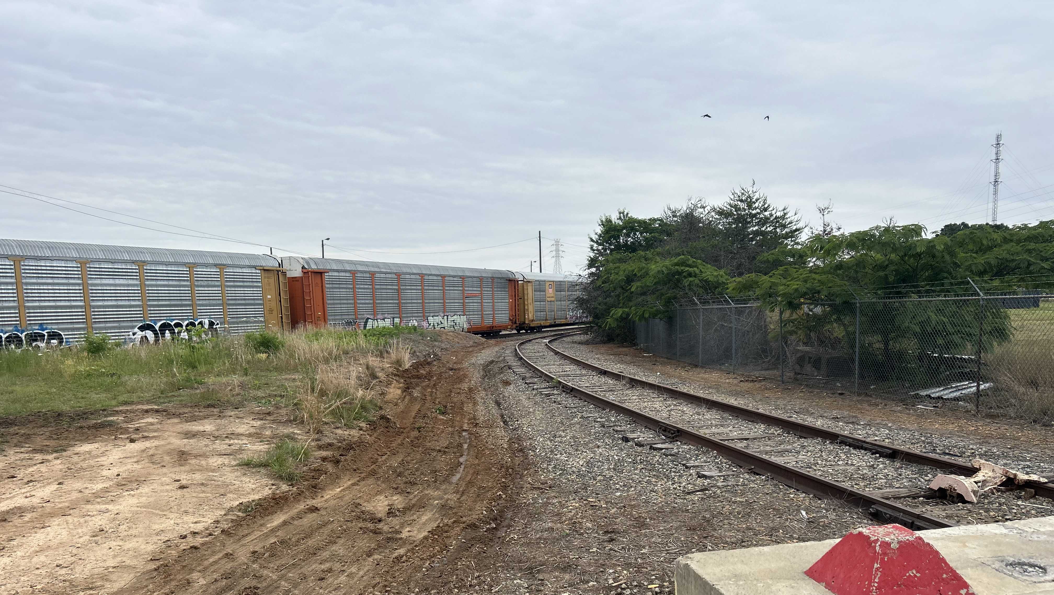 Two charged after body found in burning car on railroad tracks, deputies say