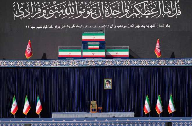The coffins of late Iranian Supreme Leader Ayatollah Ali Khamenei and members of his family are displayed on a platform above an empty chair at the start of the dayslong funeral ceremonies at the Imam Khomeini Mosalla Grand Mosque in Tehran, Iran, Saturday, July 4, 2026.