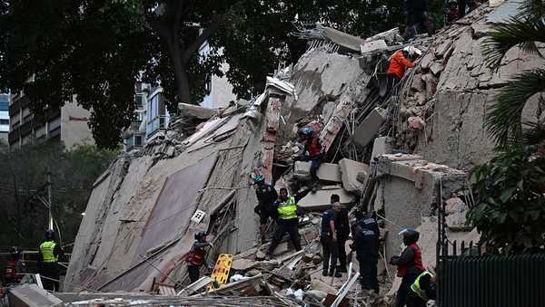 Rescuers search for victims in a collapsed building following an earthquake in Caracas on June 24, 2026.