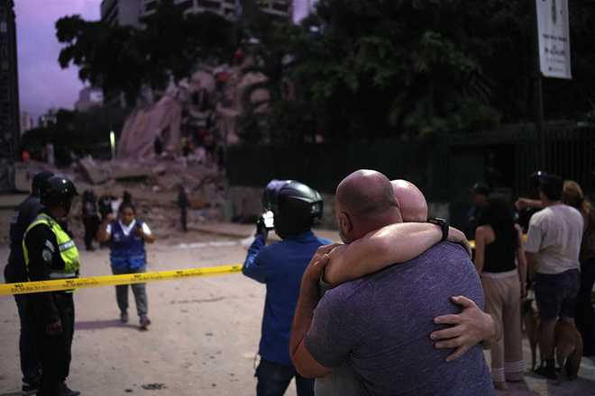 Men react in front of a collapsed building following an earthquake in Caracas, Venezuela, on June 24, 2026.
