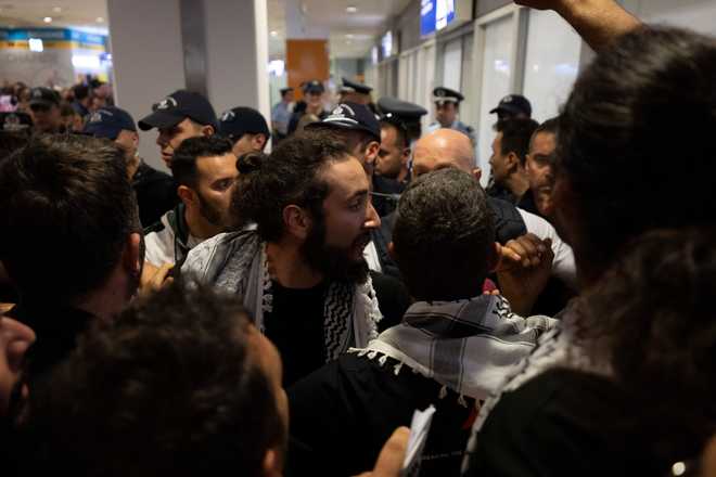 An activist from the Global Sumud Flotilla talks with the police upon his arrival at Eleftherios Venizelos International Airport in Athens, Greece, Friday, May 22, 2026.