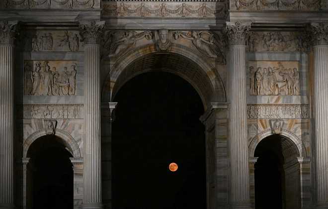 The full moon, known as the 'Strawberry Moon' rises behind the Arco della Pace ("Arch of Peace") in Milan, on June 11, 2025. (Photo by Stefano RELLANDINI / AFP) (Photo by STEFANO RELLANDINI/AFP via Getty Images)          