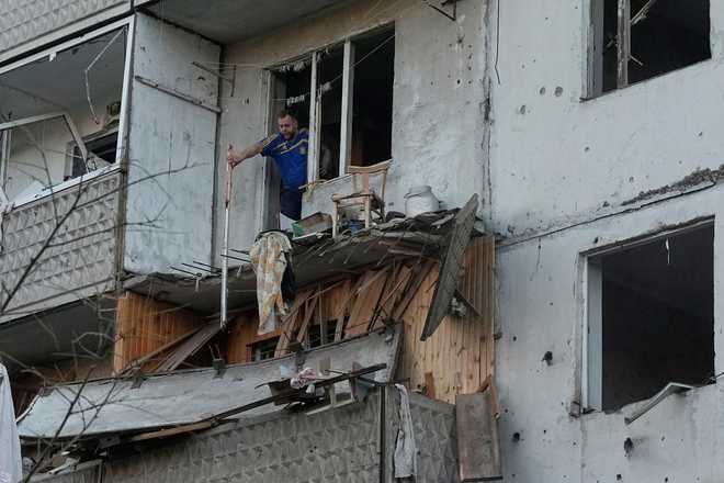 A man clears debris in his apartment building damaged after a Russian missile strike that hit in Kyiv, Ukraine, Tuesday, June 2, 2026.