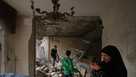 Fadi Al Zein, left, who lost both his homes in Israeli strikes in his village of Khiam and in Dahiyeh, searches through the rubble of his heavily damaged home as a child stands nearby, in Beirut's southern suburbs, Lebanon, Saturday, April 25, 2026. 