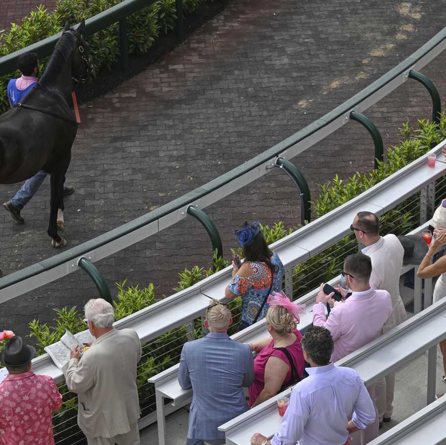 Fans watch a horse in the paddock at Churchill Downs before the 151st running of the Kentucky Oaks horse race Friday, May 2, 2025, in Louisville, Ky. (AP Photo/Jon Cherry)