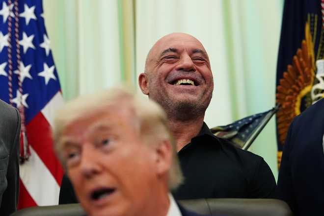 Joe Rogan laughs as President Donald Trump speaks in the Oval Office of the White House, Saturday, April 18, 2026, in Washington. (AP Photo/Julia Demaree Nikhinson)