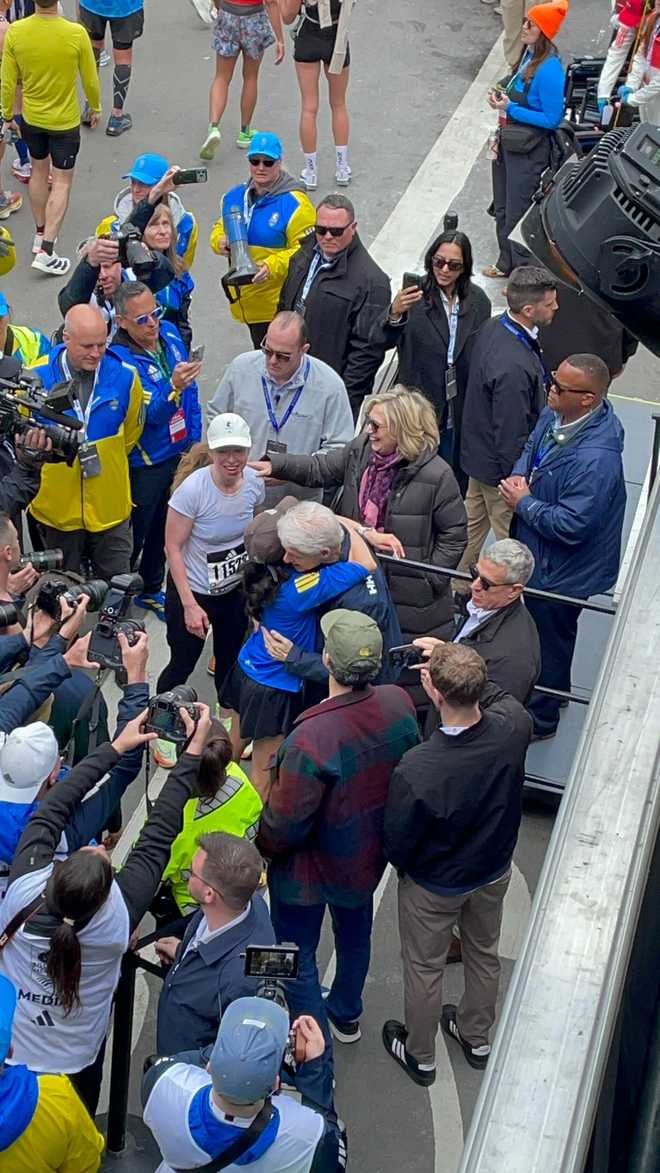 Chelsea Clinton hugs her parents after completing the Boston Marathon