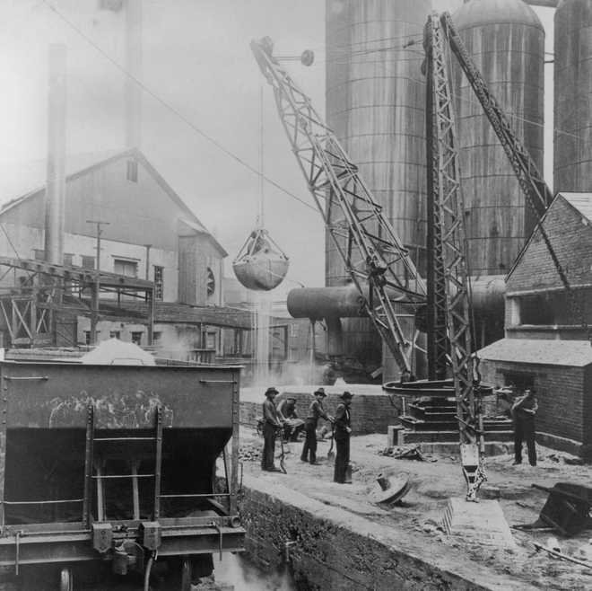 Male workers standing below a bucket attached to a crane, loading slag into a blast furnace in Pittsburgh, Pennsylvania, USA, circa 1930. Pittsburgh was long noted for its steel industry, which waned towards the end of the 20th century. (Photo by Archive Photos/Getty Images)