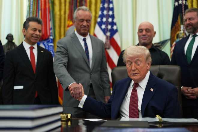 President Donald Trump shakes hands with U.S. Secretary of Health and Human Services Robert Kennedy Jr. in the Oval Office of the White House, Saturday, April 18, 2026, in Washington. (AP Photo/Julia Demaree Nikhinson)