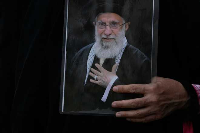 A woman holds a poster of the late Iranian Supreme Leader Ayatollah Ali Khamenei during his funeral procession in Tehran, Iran, Monday, July 6, 2026.
