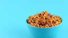 Indian Snacks Mixture,Close-up of almonds in bowl over blue background