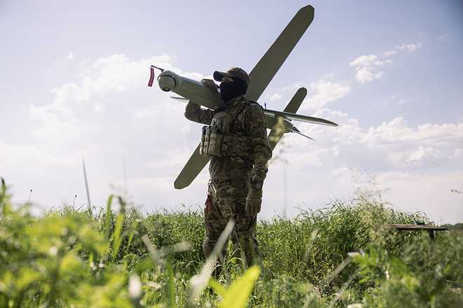 KHARKIV REGION, UKRAINE - MAY 22: (EDITOR'S NOTE: Image has been reviewed by Ukrainian military officials prior to transmission) Members of the Lava Unmanned Systems Regiment,  Norman, poses for a photograph with a Bulava strike drone, a kamikaze UAV capable of carrying a 3.5-kilogram payload with a range of up to 100 kilometres, on May 22, 2026 in Kharkiv region, Ukraine. The Lava Unmanned Systems Regiment, part of the 2nd Khartiia Corps of the Ukrainian National Guard, is a specialized unit focused on combat operations using drones and robotic systems, including deep reconnaissance and precision strikes behind enemy lines. Originally formed as a battalion in 2025, the unit was expanded into a regiment in 2026 as Ukraine increasingly relies on unmanned technologies in warfare. (Photo by Diego Fedele/Getty Images)