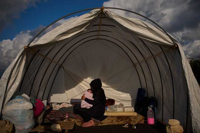 Haifa Kenjo, who fled Israeli airstrikes on the southern suburbs of Beirut, holds her 15-day-old daughter Shiman inside the tent she uses as a shelter and where she gave birth to her in Beirut, Sunday, April 12, 2026.