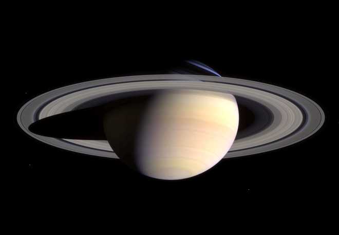 Saturn's peaceful beauty invites the Cassini spacecraft for a closer look in this natural color view, taken during the spacecraft's approach to the planet. By this point in the approach sequence, Saturn was large enough that two narrow angle camera images were required to capture an end-to-end view of the planet, its delicate rings and several of its icy moons. The composite is made entire from these two images.  Moons visible in this mosaic: Epimetheus (116 kilometers, 72 miles across), Pandora (84 kilometers, 52 miles across) and Mimas (398 kilometers, 247 miles across) at left of Saturn; Prometheus (102 kilometers, 63 miles across), Janus (181 kilometers, 113 miles across) and Enceladus (499 kilometers, 310 miles across) at right of Saturn.    (Photo by NASA/WireImage) *** Local Caption ***