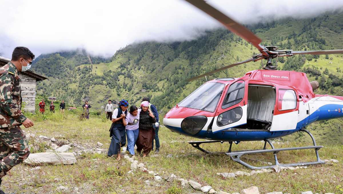 Rescuers comb through mud as Nepal-China floods leave more than 1,000 dead