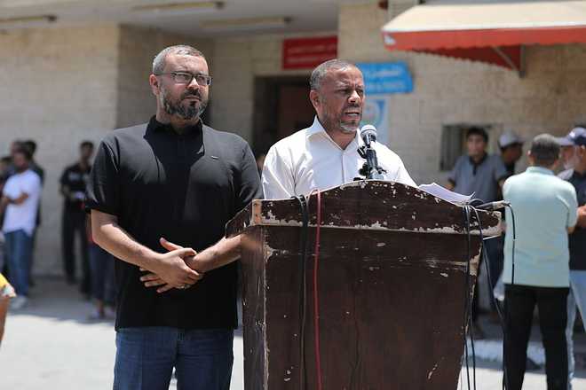 Hamas spokesperson Hazem Qassem and Director of the Government Media Office in Gaza Ismail Al-Thawabta deliver a press statement outside Al-Aqsa Martyrs Hospital following the announcement that the head of the Government Emergency Committee had resigned and the committee had been dissolved as part of the transfer of governance in the Gaza Strip to the National Gaza Administration Committee, on July 6, 2026, in Deir al-Balah, Palestine.