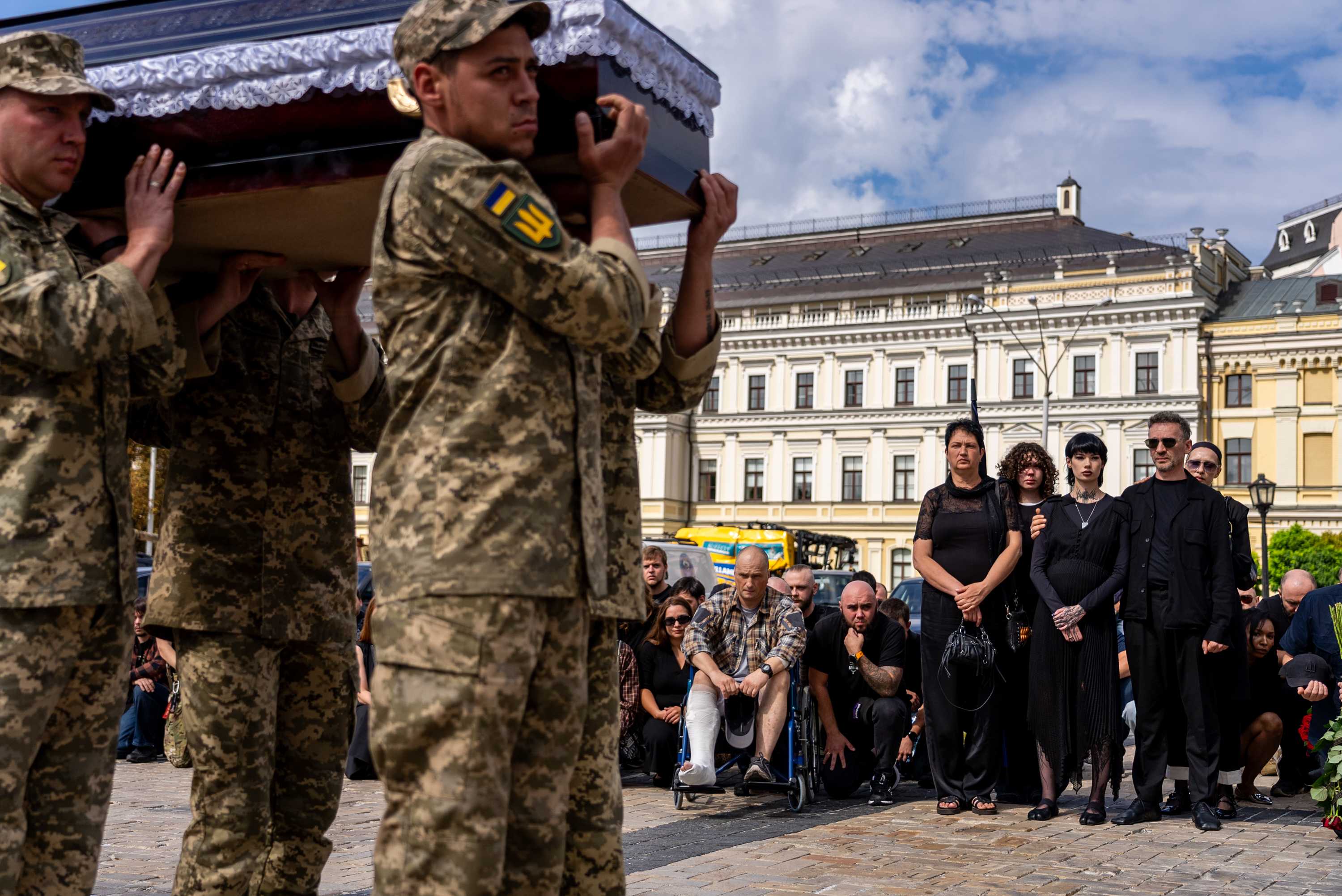 A pregnant soldier mourns her husband at his funeral in Ukraine