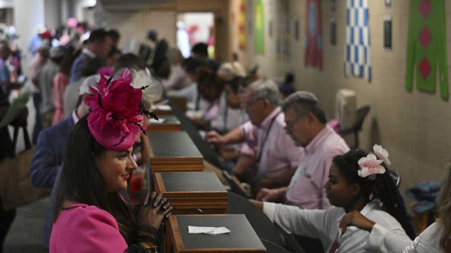 A person places a bet at Churchill Downs before the 151st running of the Kentucky Oaks horse race Friday, May 2, 2025, in Louisville, Ky. (AP Photo/Jon Cherry)
