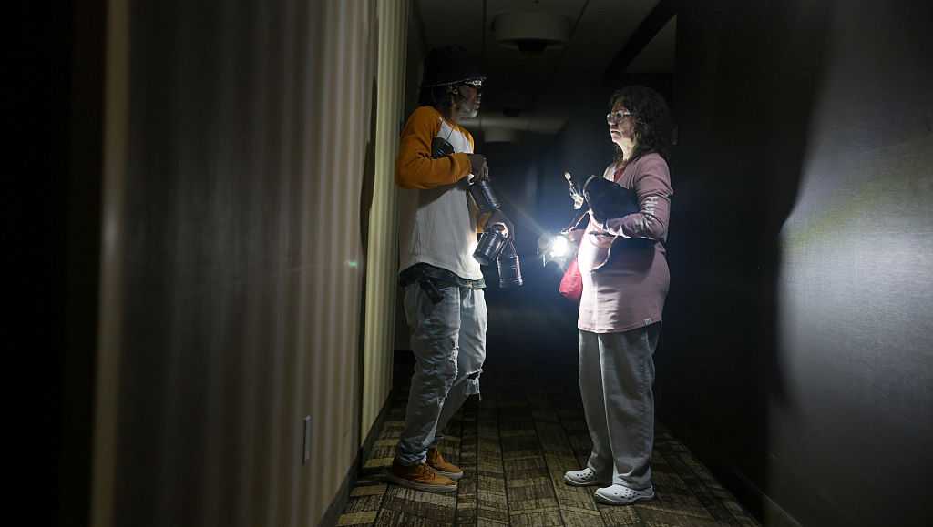 Photo: wcvb.com Kevin Hudgins (L) helps guest Laura Gower after a power outage at the Residence Inn as Hurricane Isaias passes through the
