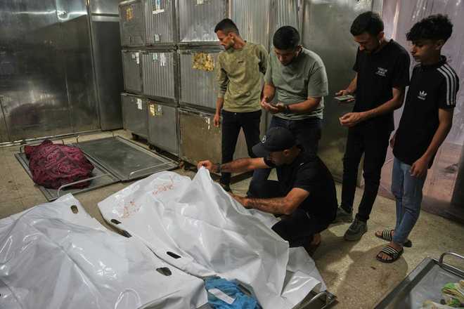 Mourners take the last look at the bodies of two Palestinian girls Zeina Safadi, and her sister Lana, who were killed during an overnight Israeli airstrike that damaged their home, during their funeral in Gaza City, Saturday, June 20, 2026.