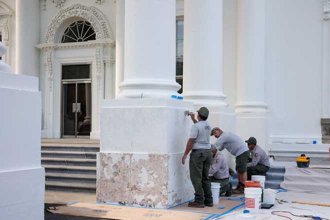 The door of the North Portico of the White House is visible as workers perform maintenance on the portico's columns on June 22.