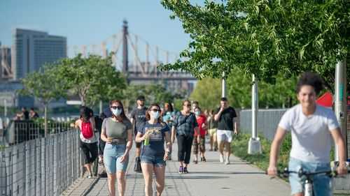 People walk in Gantry Plaza State Park in New York City.