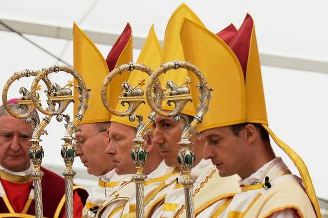 Newly consecrated Bishops, from left, Pascal Schreiber, Michael Goldade, Michel Poinsinet de Sivry and Marc Hanappier, wearing their miters and holding their pastoral staffs, pray at the end of their consecration ceremony in a tent set up outside the Society of St. Pius X seminary in Econe, Switzerland, Wednesday, July 1, 2026. (AP Photo/Baz Ratner)