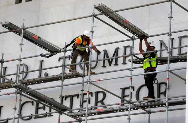 Workers construct scaffolding at the sign for the John F. Kennedy Center for the Performing Arts, Friday, June 12, 2026, in Washington.