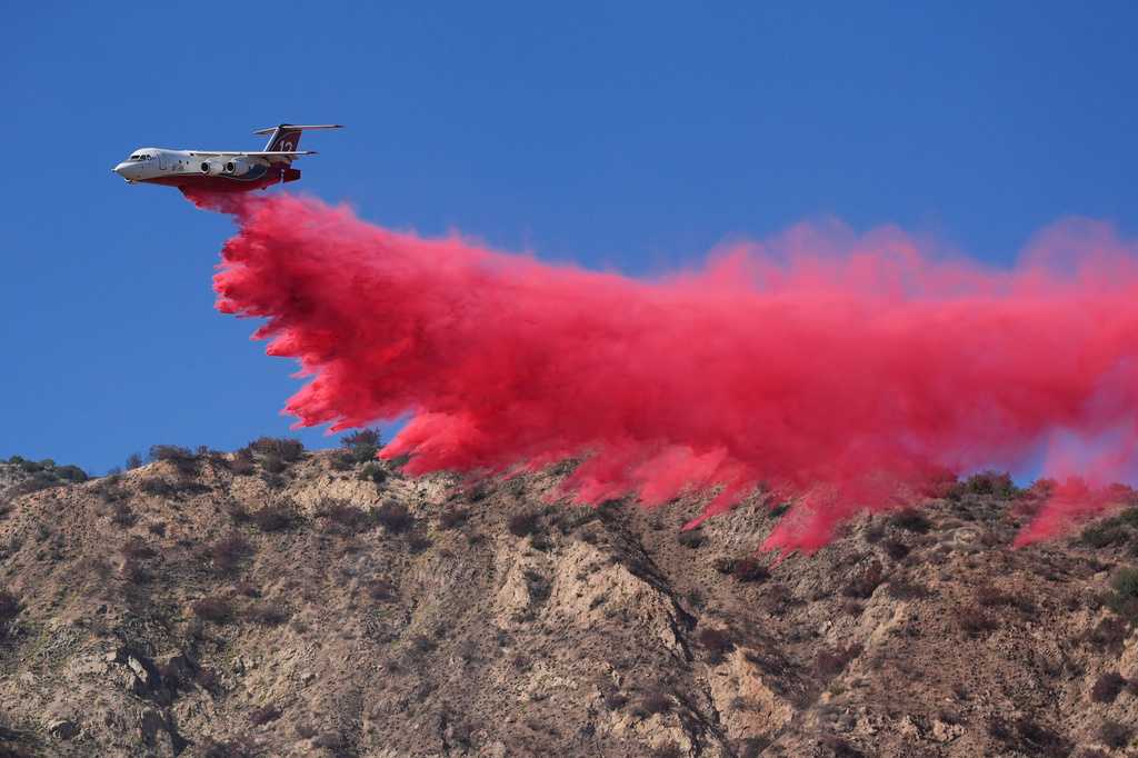 Multiple Southern California homes are ablaze in a fast-moving wildfire fueled by hot, windy weather