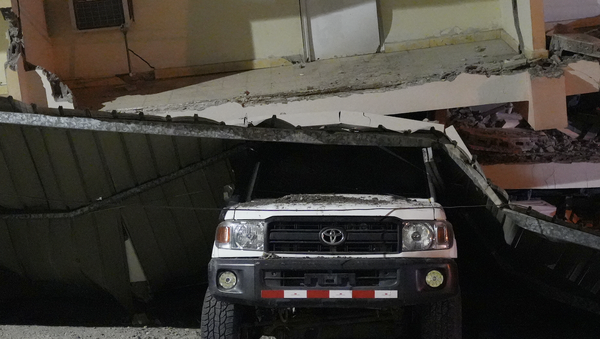 A vehicle lies crushed beneath a collapsed building after an earthquake struck Penonome, Panama, Friday, Oct. 9, 2026.