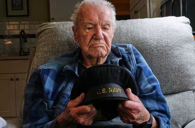 Freeman K. Johnson, a 106-year-old Pearl Harbor survivor, looks down at his flat cap during an interview at his home, May 6, 2026, in Centerville, Mass. (AP Photo/Charles Krupa)