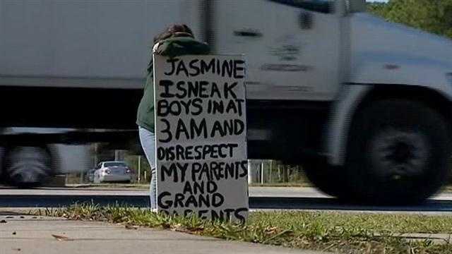 Parents upset with daughter's behavior force her to wear sign