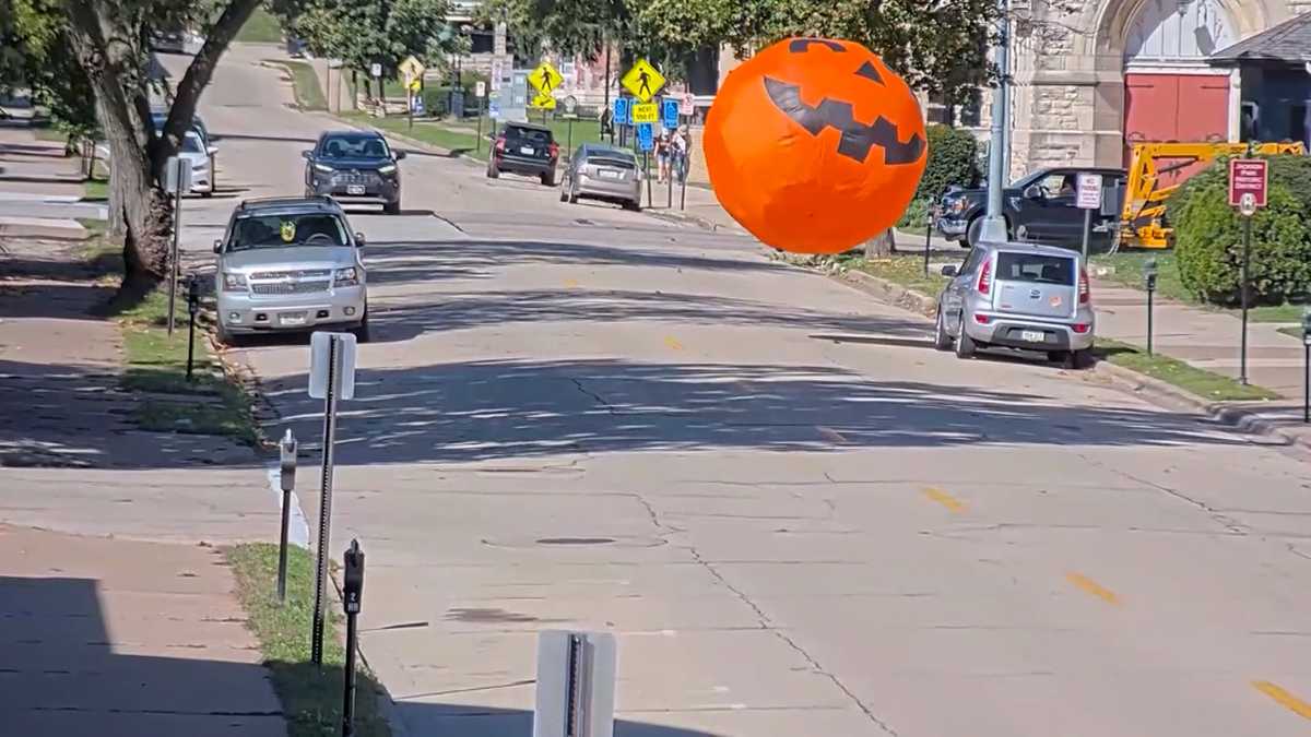 Wind-blown inflatable pumpkin rolls through Dubuque street
