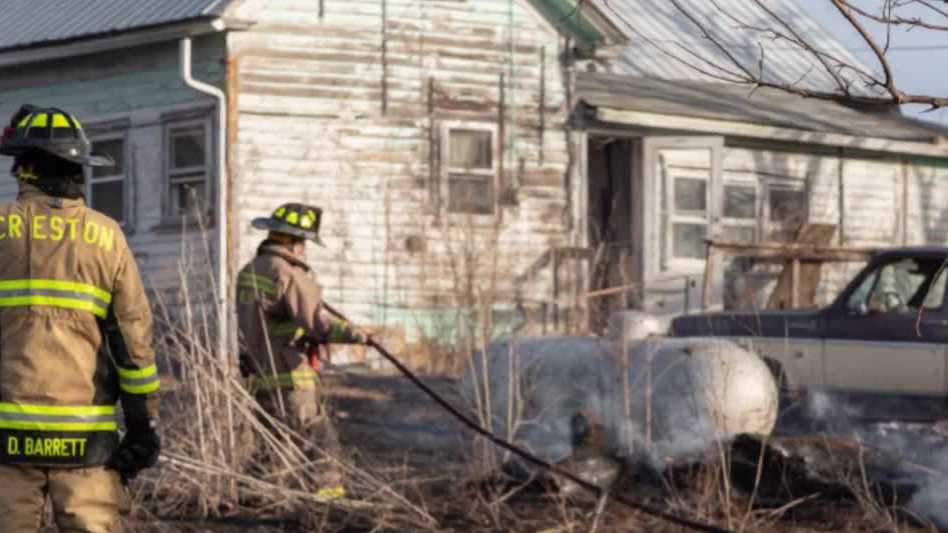 Iowa crews extinguish grass fire involving a building