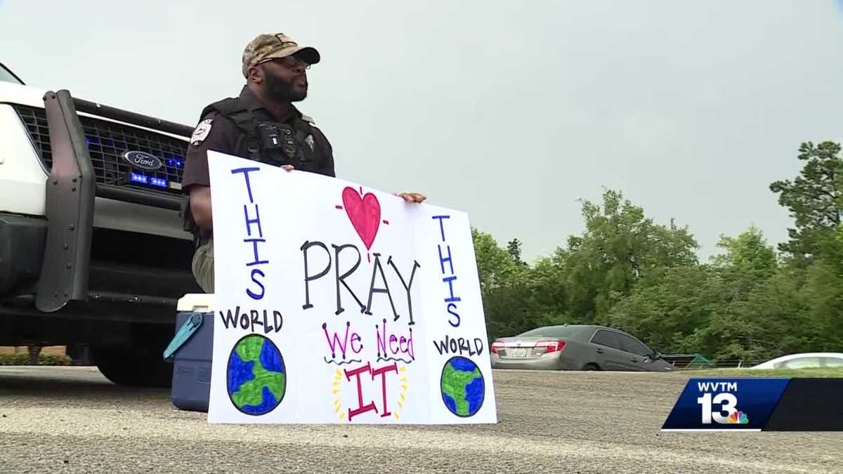 Kimberly Police Officer Darnell Blankenship holds sign outside of