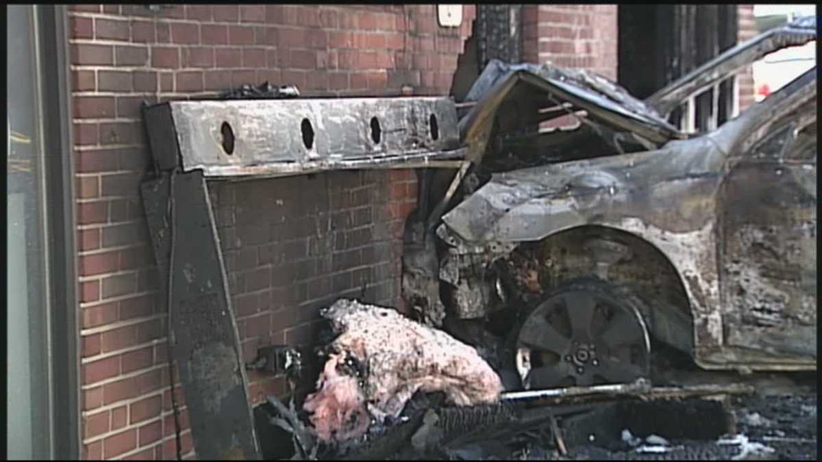 Car crashes into dealership, catches fire