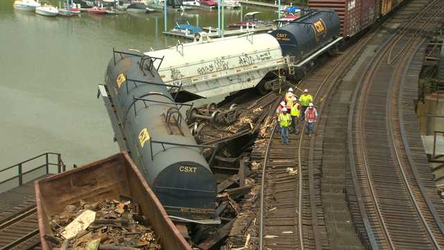 Derailed train cars dangle over Yough River