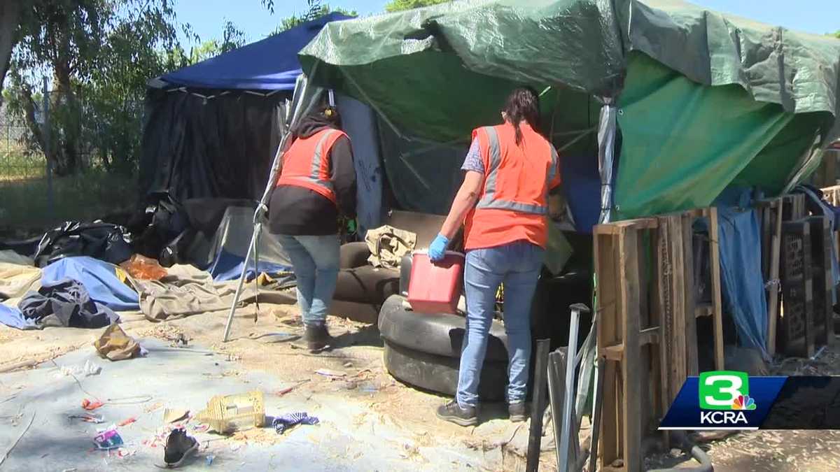 Homeless people line Sacramento County road after being evicted from camp