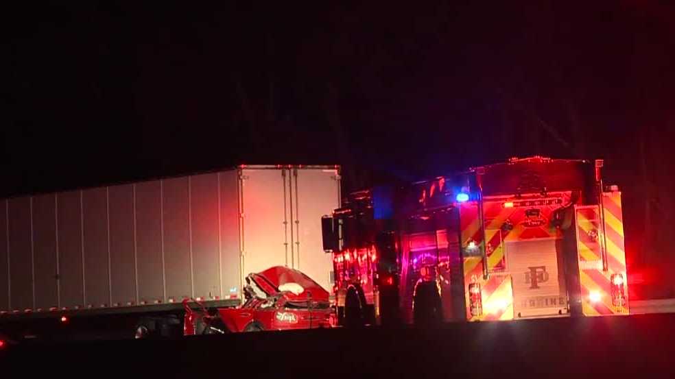 Woman dies when car crashes into tractor-trailer