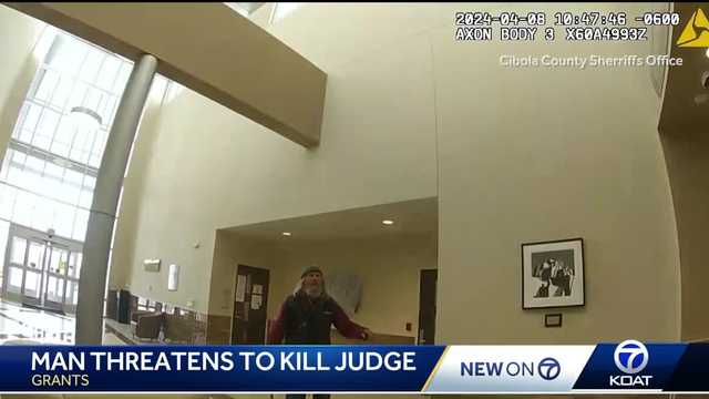 shows man carrying ax into Cibola County Courthouse