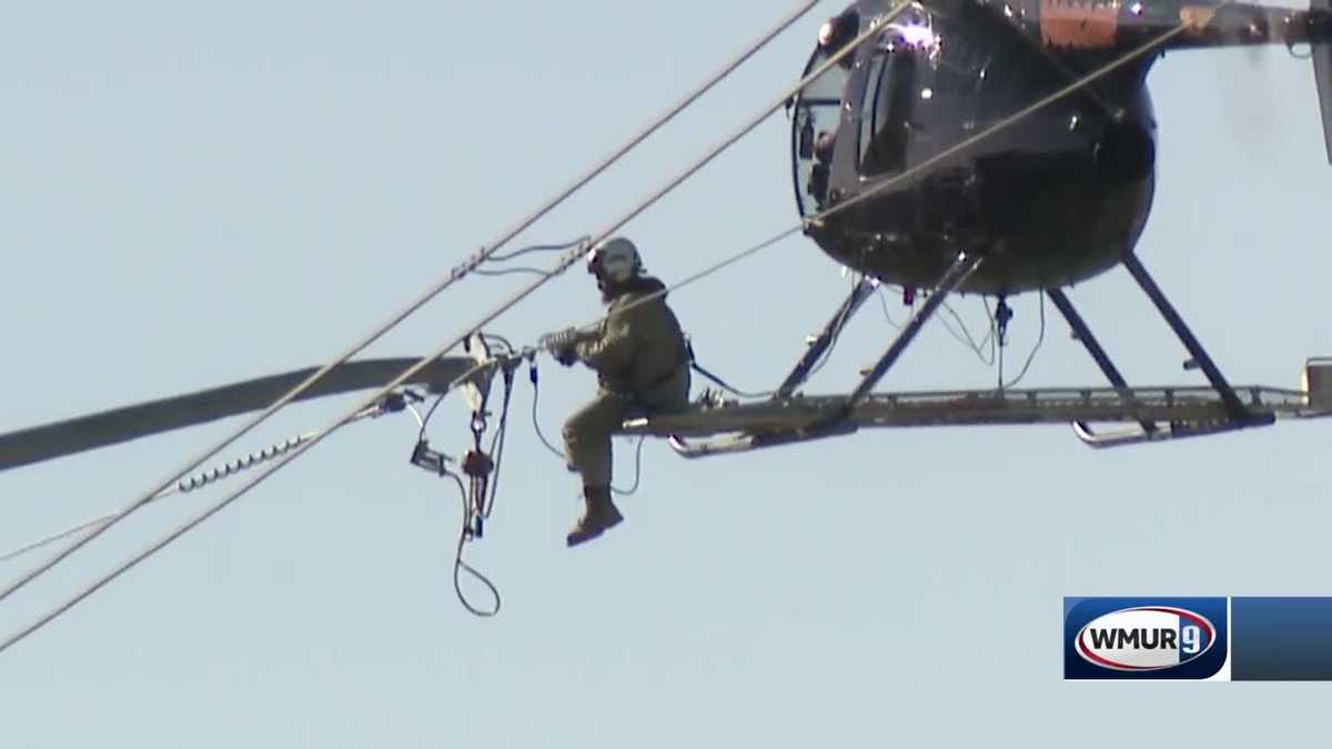 Workers suspend from helicopters to upgrade power lines