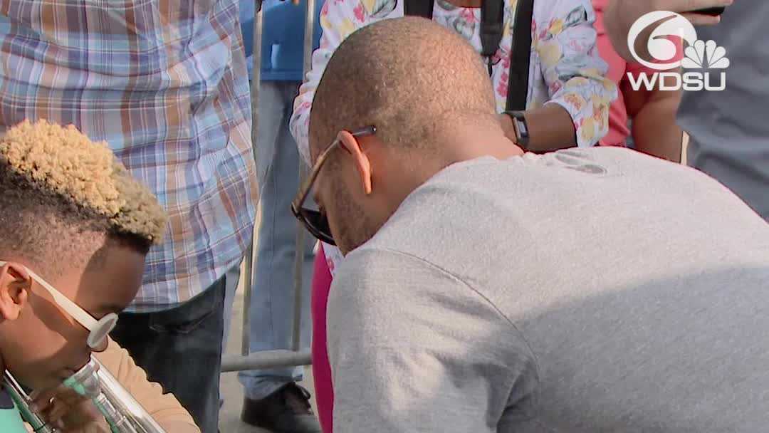 Trombone Shorty gives child music lesson at Art Neville's second line