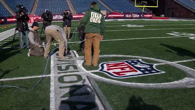 Patriots stadium crew painting NFL playoff logos on field