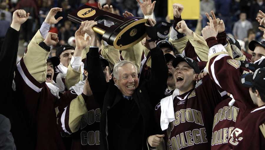 Boston College head coach Jerry York, center, holds up the championship trophy while celebrating their 5-0 victory over Wisconsin in the NCAA Frozen Four championship hockey game in Detroit, Saturday, April 10, 2010.