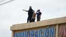 Law enforcement agents look around the roof of an apartment building near the scene of a shooting at a U.S. Immigration and Customs Enforcement office in Dallas on Wednesday, Sept. 24, 2025. (AP Photo/Julio Cortez)