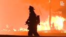 firefighter silhouetted by flames