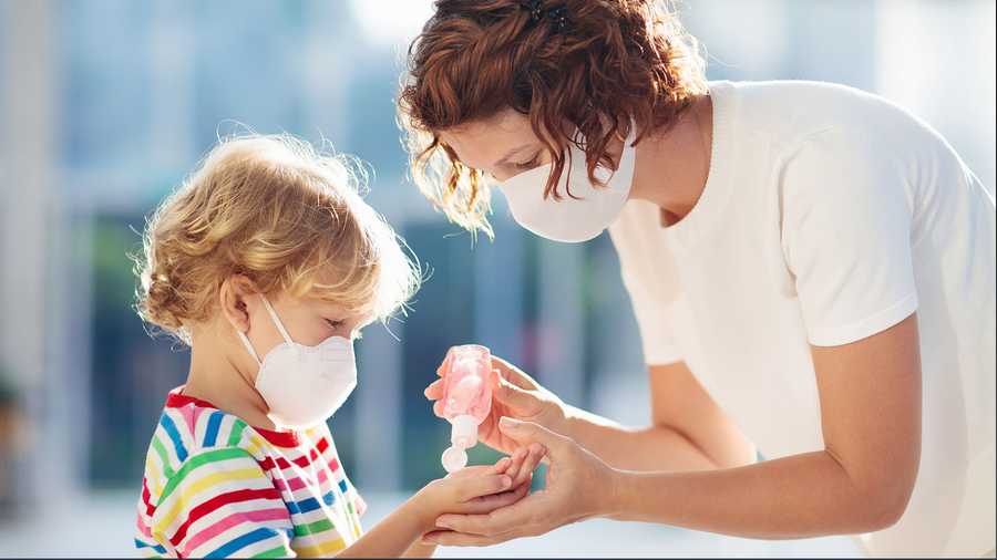 Child wearing face mask with mother