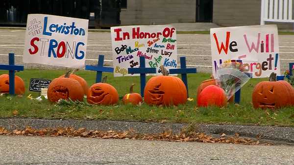 Carved pumpkins featuring the names of the 18 people killed in two shootings in Lewiston, Maine, on Oct. 25, 2023 have been added to the growing memorial outside Just-in-Time Recreation, a bowling alley where seven of the victims died.